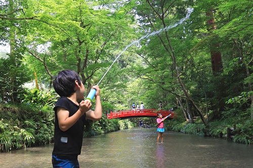 川で水鉄砲で遊んでいる子どもたち