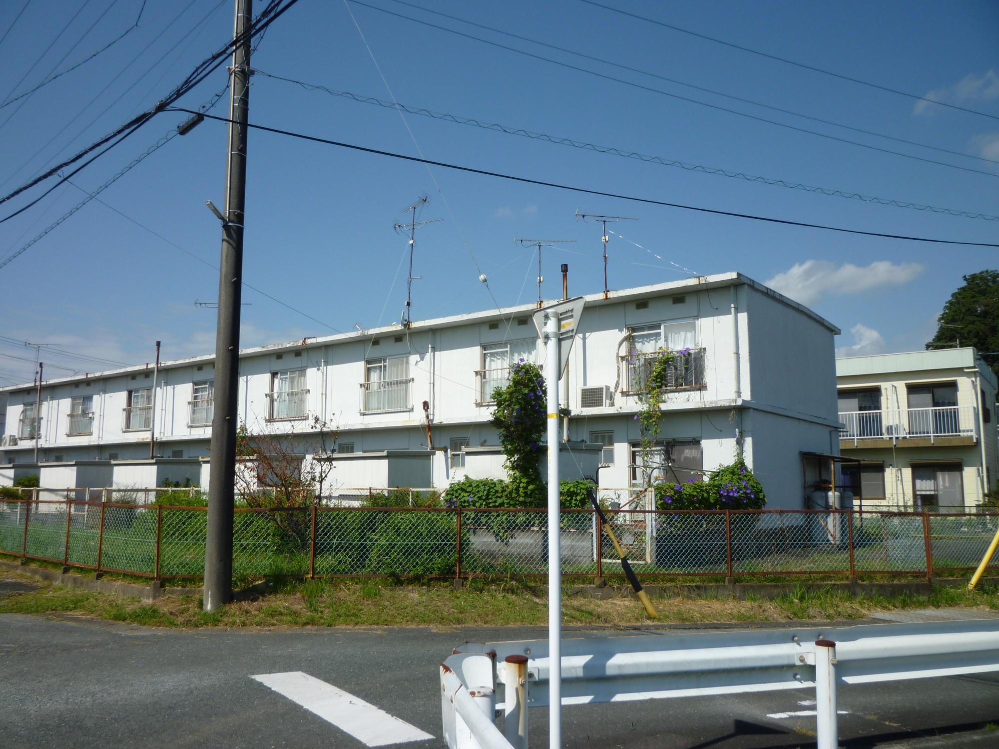 2階建て白い外観の町営住宅中川第2団地の写真