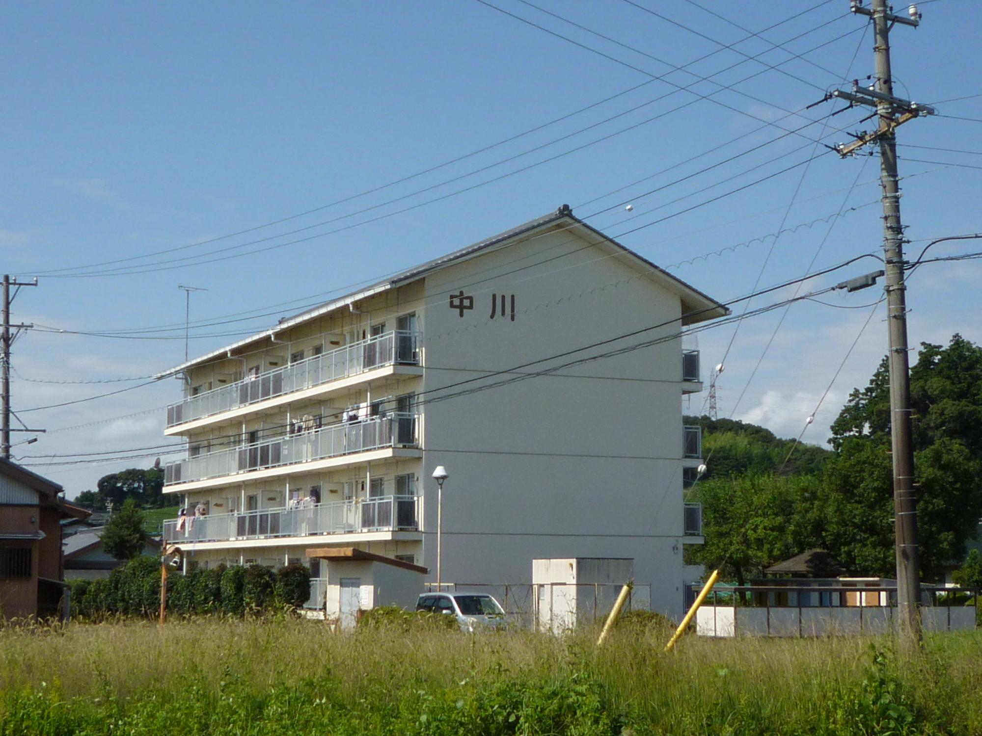 4階建て白い外観の町営住宅中川団地の写真