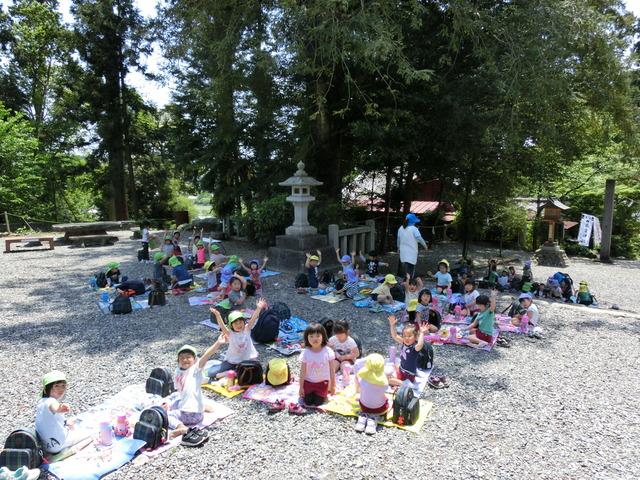 天宮神社の境内で、灯籠の近くにそれぞれがシートを敷き、両手を上げたりポーズをとっている写真